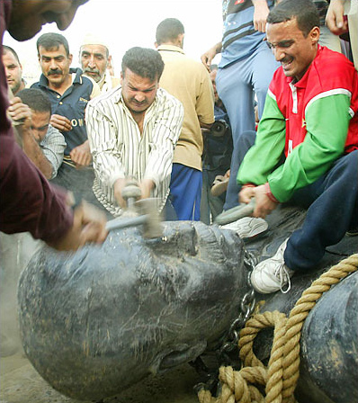 Iraqis destroy a statue of Saddam Hussein after it was pulled down by the U.S. military, central Baghdad, April 9, 2003.
